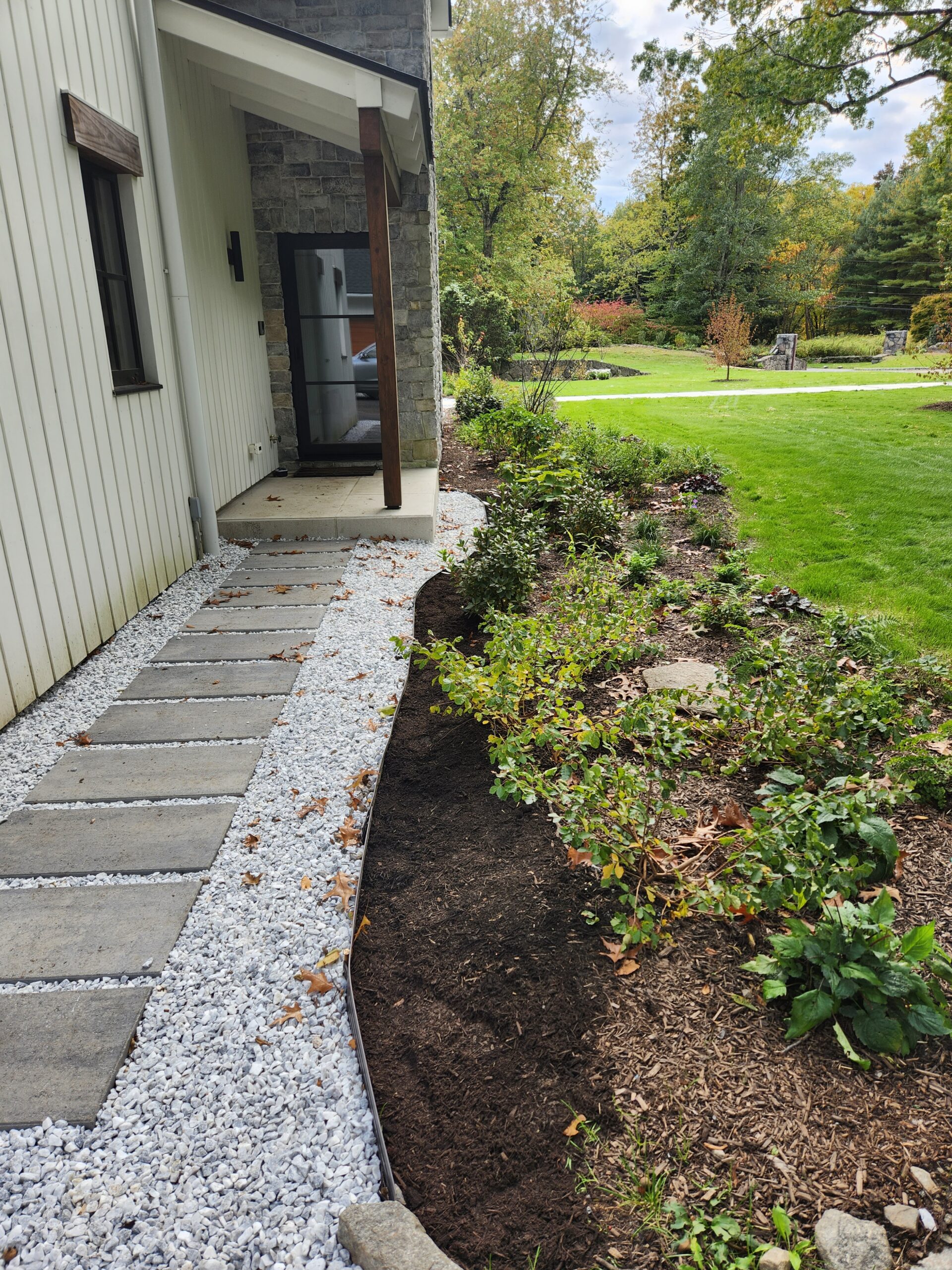 Mixed natural stone hardscape and contemporary front foundation planting.
